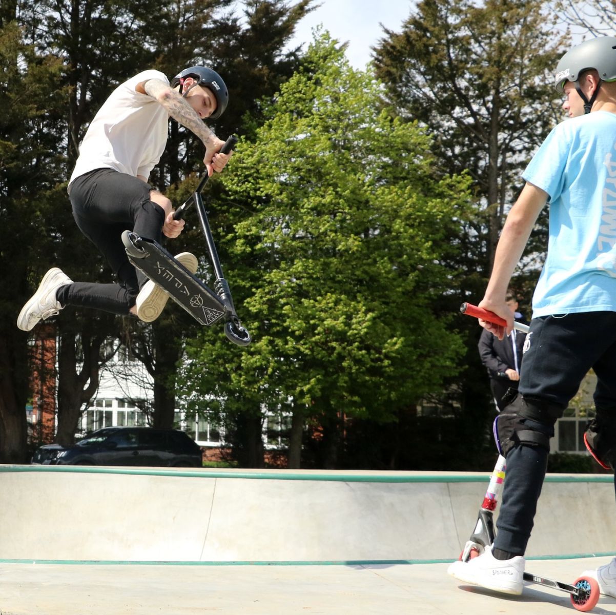 Young people doing stunts on scooters at Leiston Skate Park Suffolk